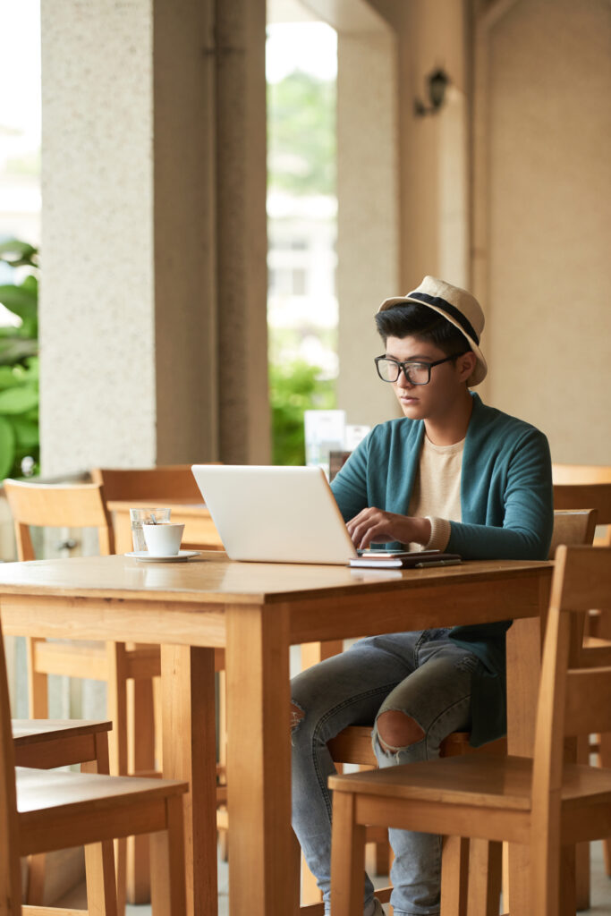 A student studying with a laptop, surrounded by books and notes, creating an ideal online learning environment.